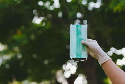 Close-up of hand holding drink against blurred background