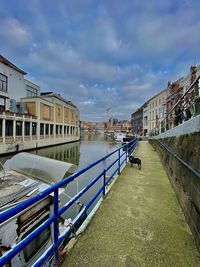 Canal amidst buildings in city against sky