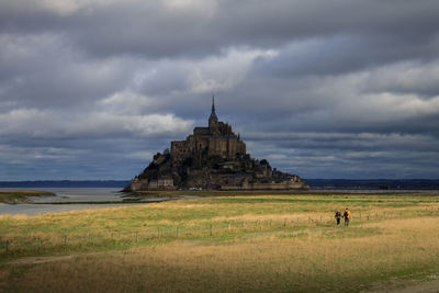 Scenic view of the mont saint michel in contrast light with couple on the foreground