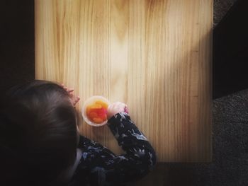 Directly above view of baby eating from bowl on table