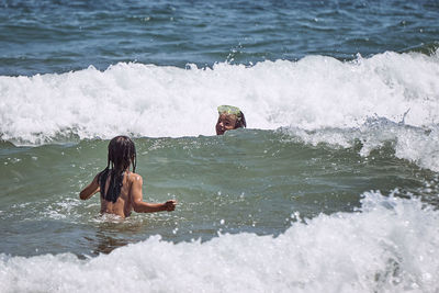 High angle view of shirtless man swimming in sea