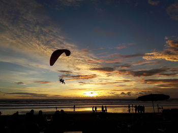 Silhouette person on beach against sky during sunset