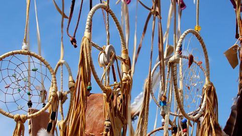 Close-up of dreamcatchers hanging against sky