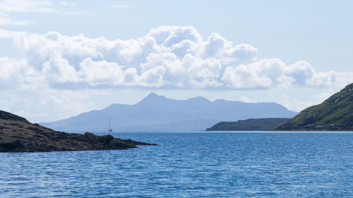 Scenic view of sea and mountains against sky