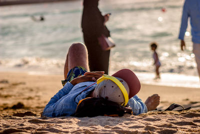 Close-up of man lying on beach