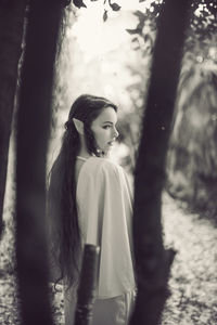 Young woman looking away while standing on land