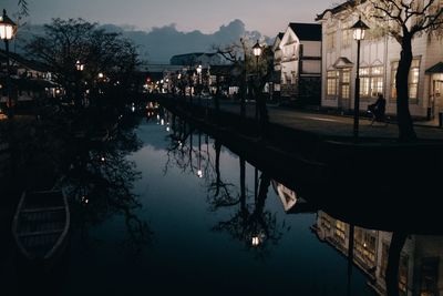 Canal amidst buildings in city at night