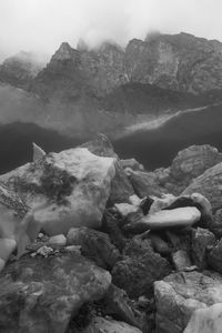 Rocks in lake against mountains