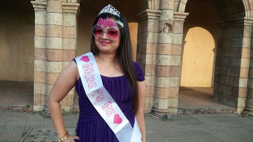 Portrait of smiling young woman wearing bridesmaid sash at vardhman fantasy amusement park