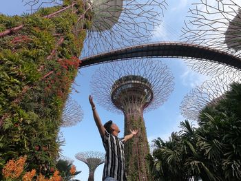 Low angle view of man standing by palm trees