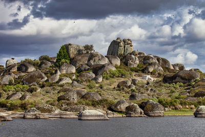Rock formations by sea against sky