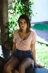 Portrait of young woman sitting outdoors