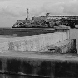 Historic buildings at sea shore against sky