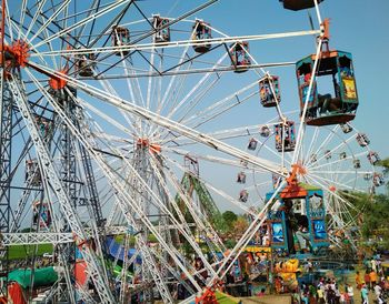 Low angle view of chain swing ride against sky