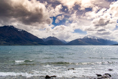 Scenic view of sea and mountains against sky