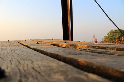 Surface level of wooden post against clear sky