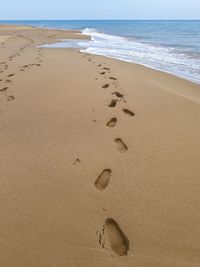 High angle view of footprints on sand at beach