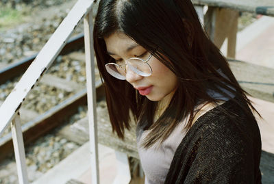 Close-up of thoughtful woman wearing eyeglasses on steps