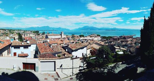 High angle view of town by sea against sky