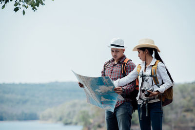 Young woman with umbrella standing against white background