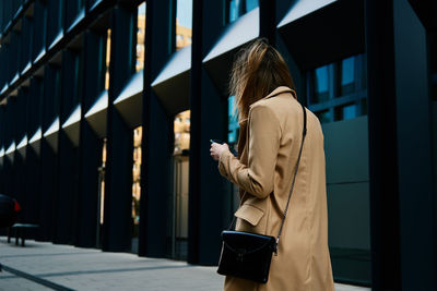 Caucasian woman using smartphine at city street