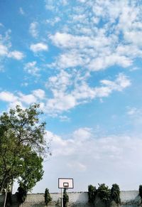 Low angle view of trees and building against sky