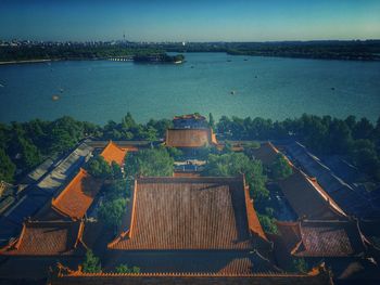 High angle view of buildings by river against sky