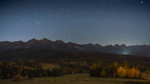 Scenic view of mountains against sky at night