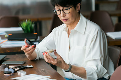 Young woman using mobile phone while sitting at home