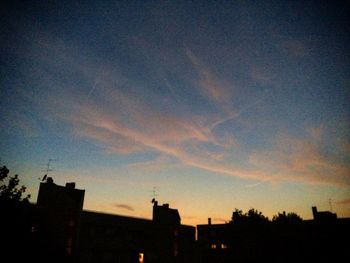High section of silhouette buildings against sky