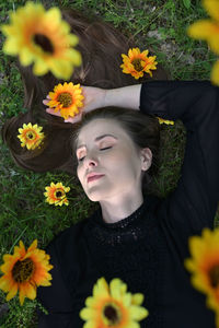 Low angle view of woman amidst flowering plants