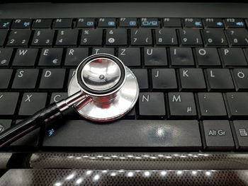 High angle view of stethoscope examining computer keyboard