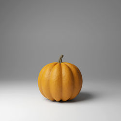 Close-up of pumpkin against orange background