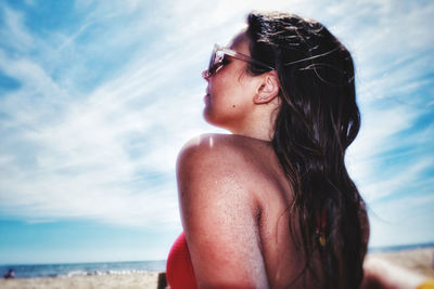 Portrait of beautiful woman on beach against sky