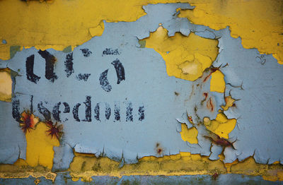 Close-up of text on yellow wall