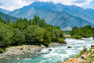 Scenic view of river amidst mountains against sky