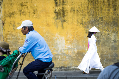 Rear view of people riding bicycle