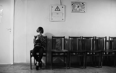 Rear view of kid sitting on chair in a corridor
