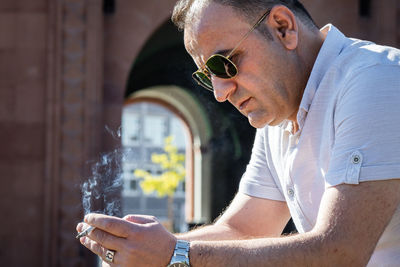 Midsection of man holding eyeglasses