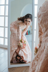 Portrait of young woman standing at home