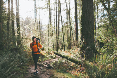 Full length of woman with child walking in forest