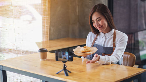 Portrait of young woman working at table