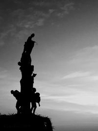 Low angle view of silhouette statue against sky