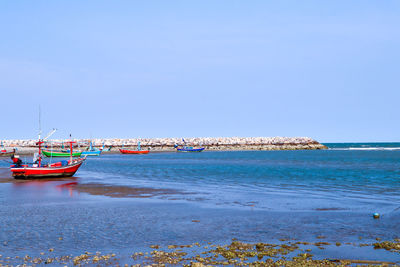 View of boats in sea against clear sky