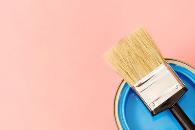 High angle view of paintbrush against pink background