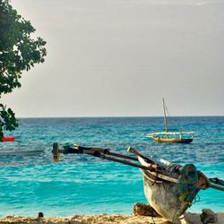 Boat on shore at beach against sky