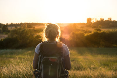 Rear view of woman standing on field against clear sky