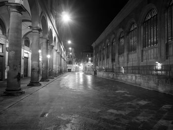 Illuminated street amidst buildings at night