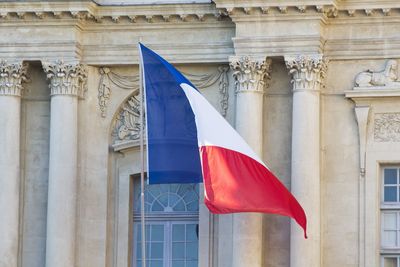 Low angle view of france flag against built structure
