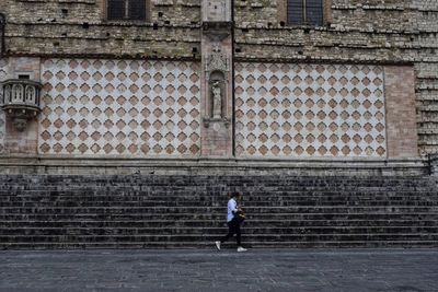 Full length of man standing on wall of building